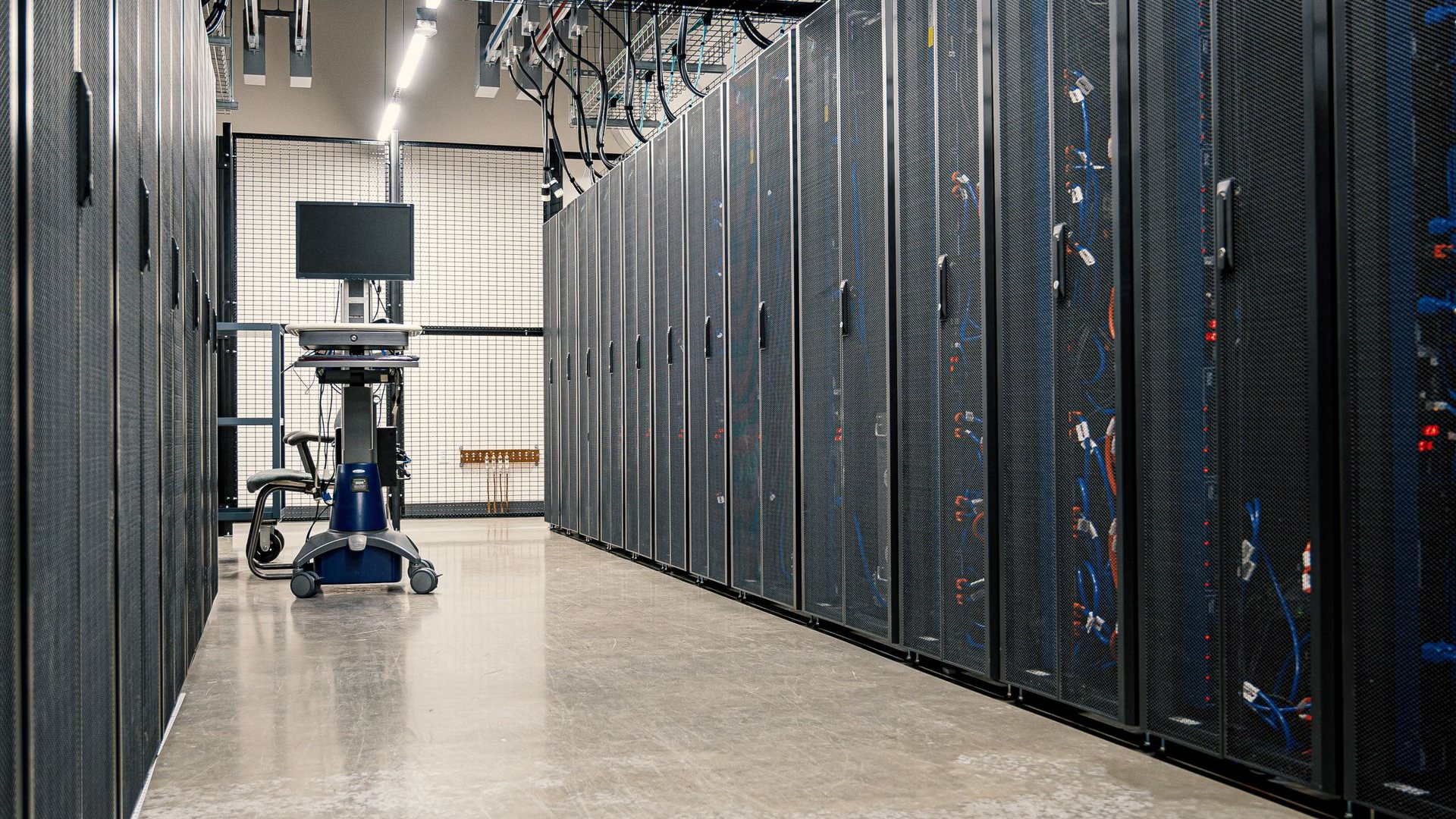 Aisle of server racks in a data centre, representing the enterprise estate a cryptographic exposure management platform must discover